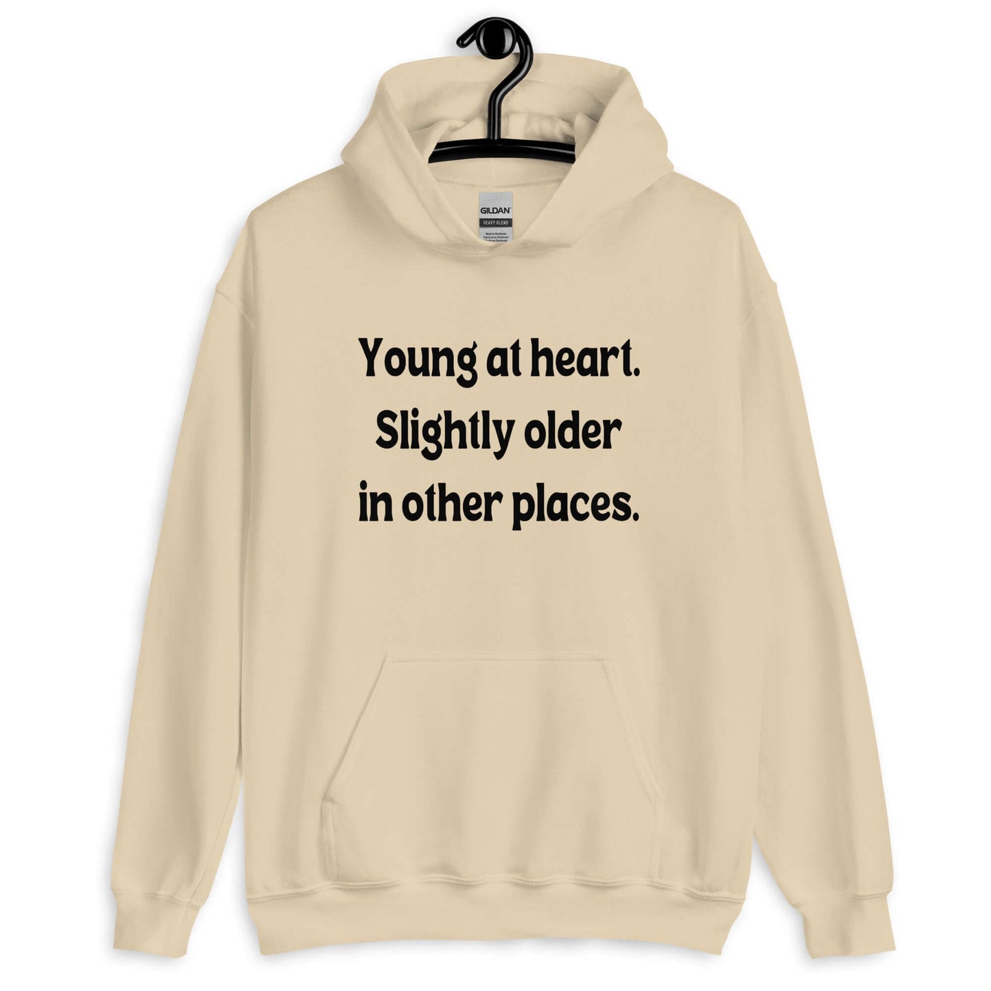 Sand hoodie sweatshirt with the words Young at heart, slightly older in other places printed on the front.