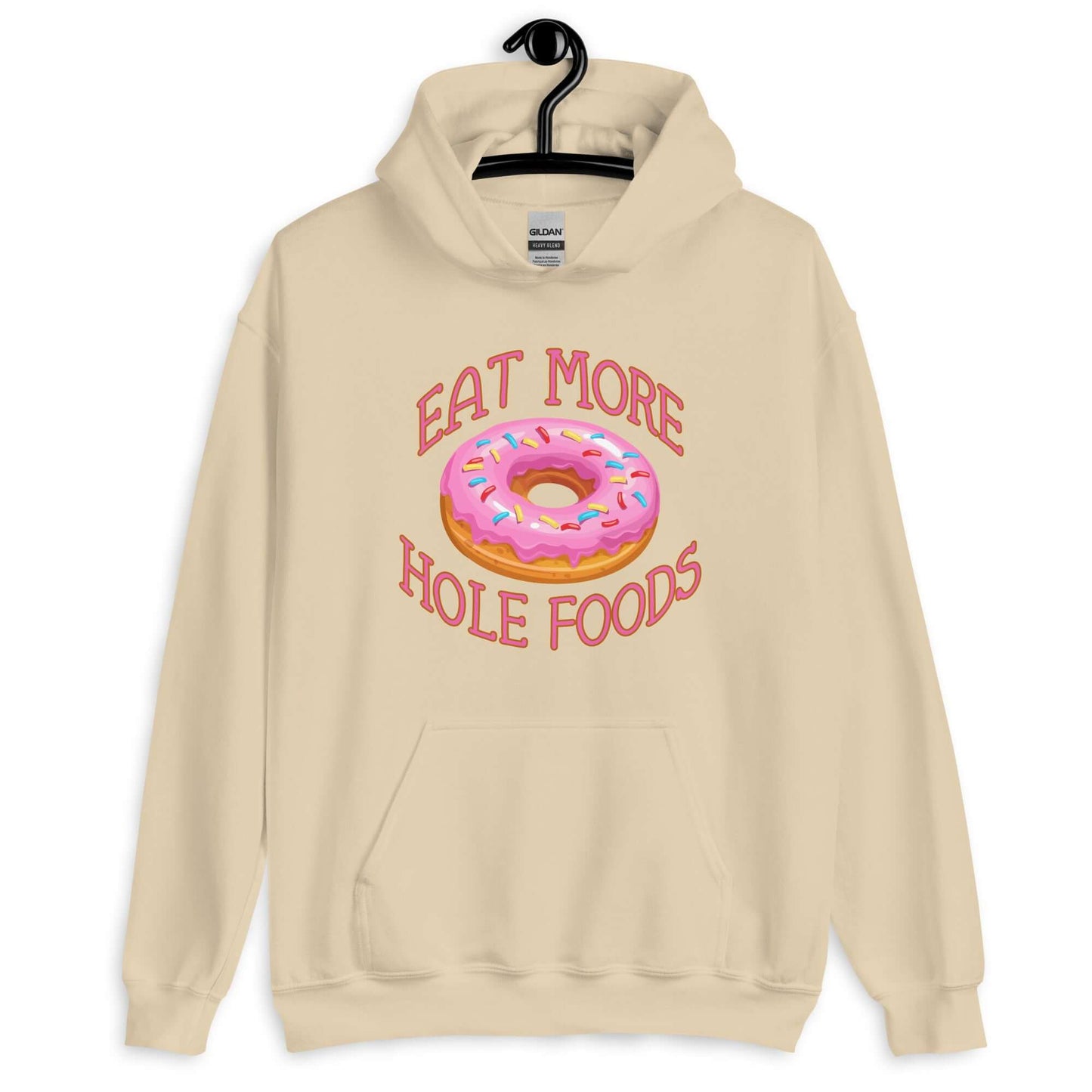 Sand color hoodie sweatshirt with an image of a donut with pink icing and sprinkles and the words Eat more hole foods printed on the front.