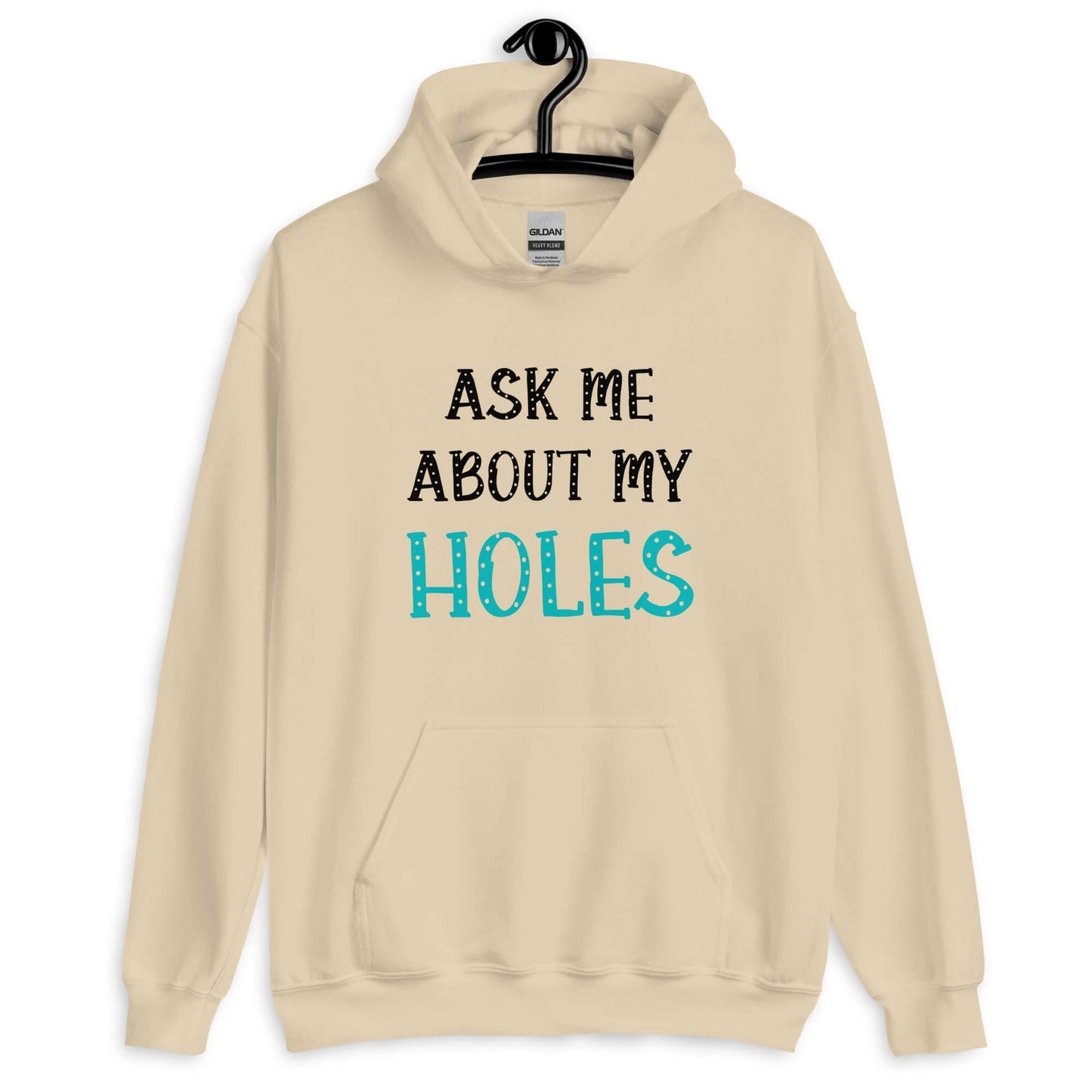 Sand hoodie sweatshirt with the words Ask me about my holes printed on the front. The word holes in turquoise color and the rest of the text is black.