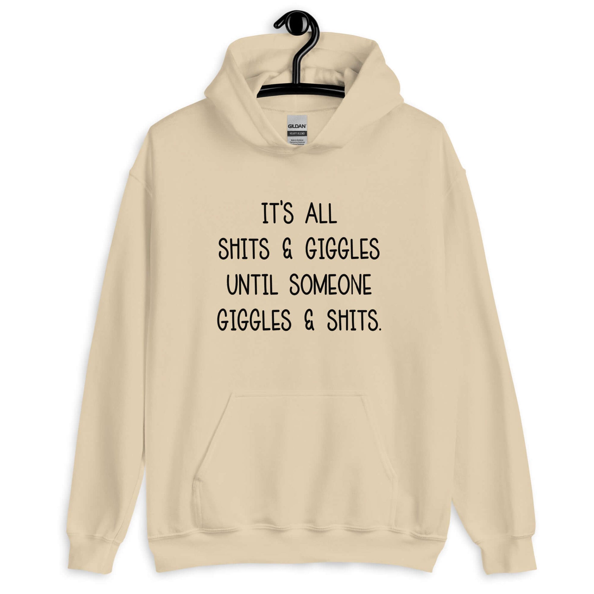 Sand color hoodie sweatshirt with the phrase It's all shits & giggles until someone giggles & shits printed on the front.