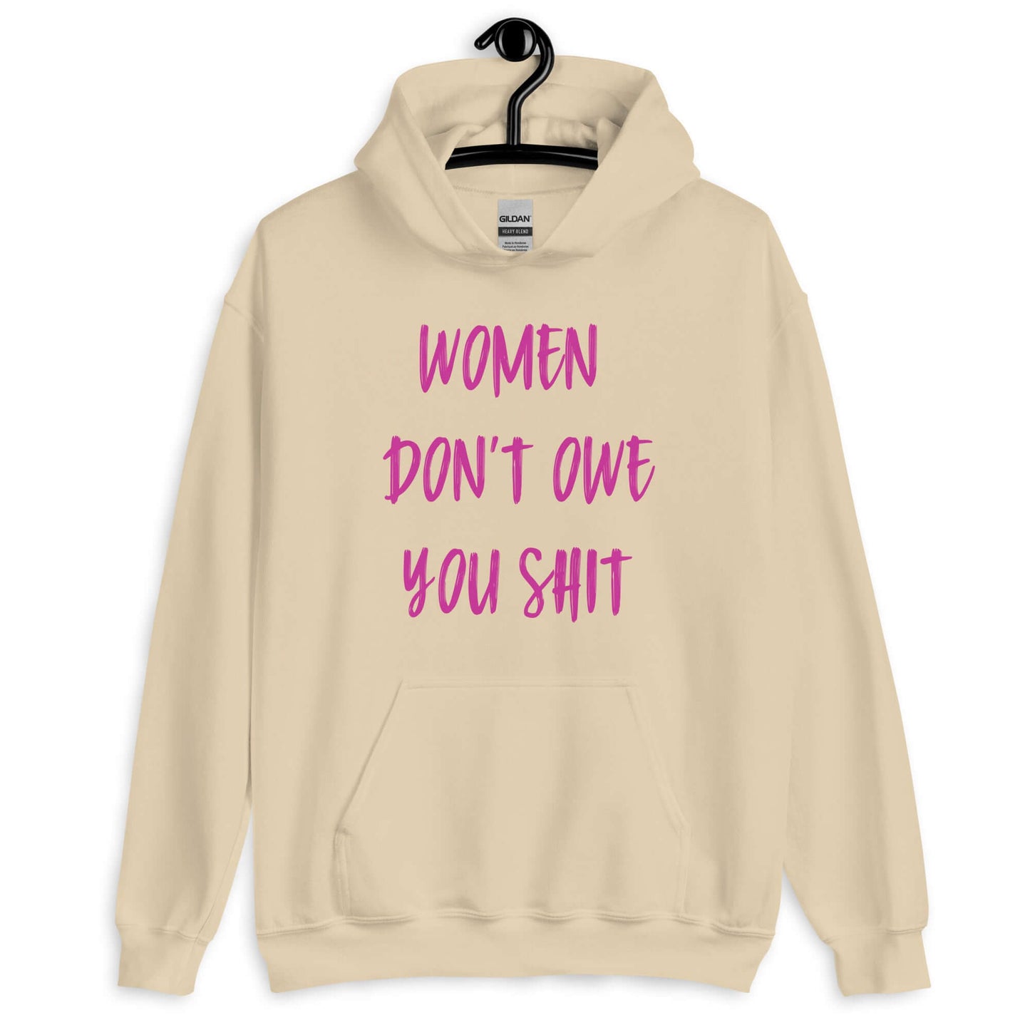 Sand color hoodie sweatshirt with the words Women don't owe you shit printed on the front in pink.