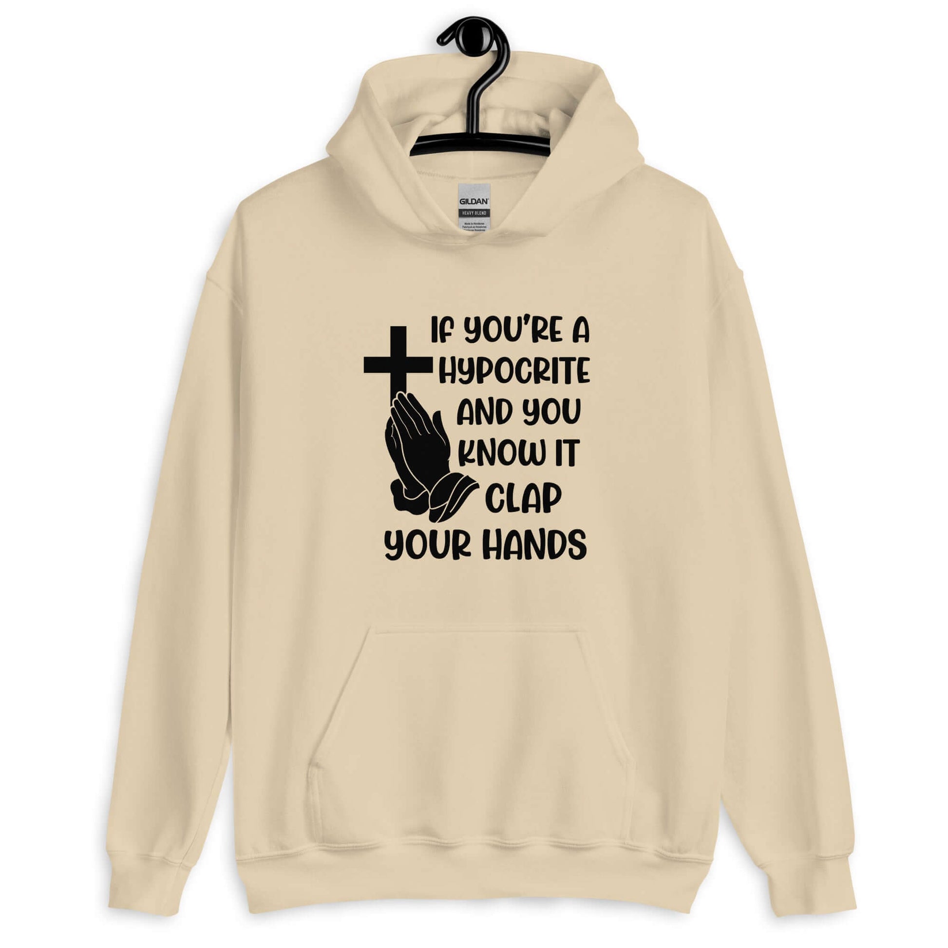 Sand color hoodie sweatshirt with image of a cross and praying hands & the phrase If you're a hypocrite and you know it clap your hands printed on the front.