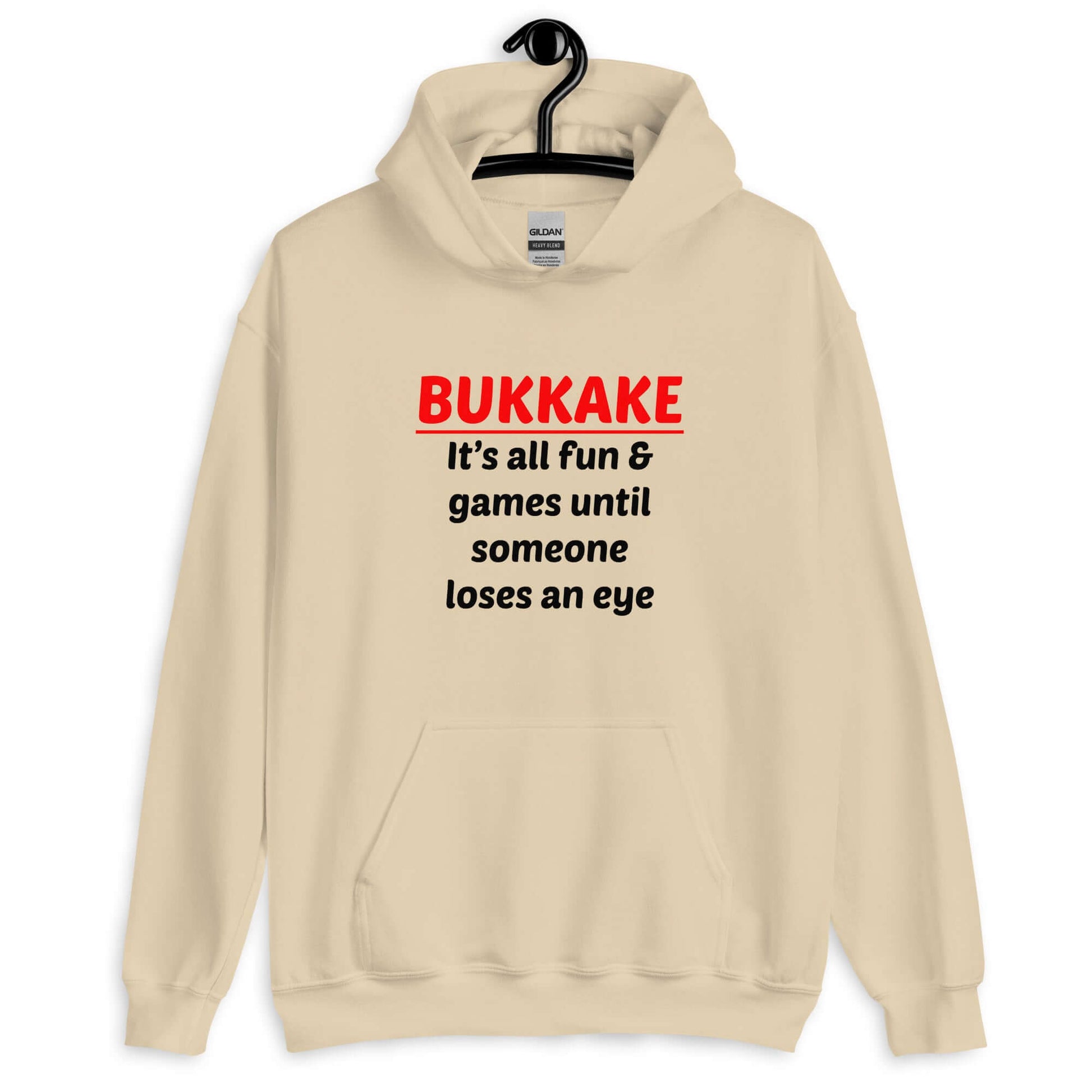 Sand color hoodie sweatshirt with the phrase Bukkake it's all fun & games until someone loses an eye printed on the front.