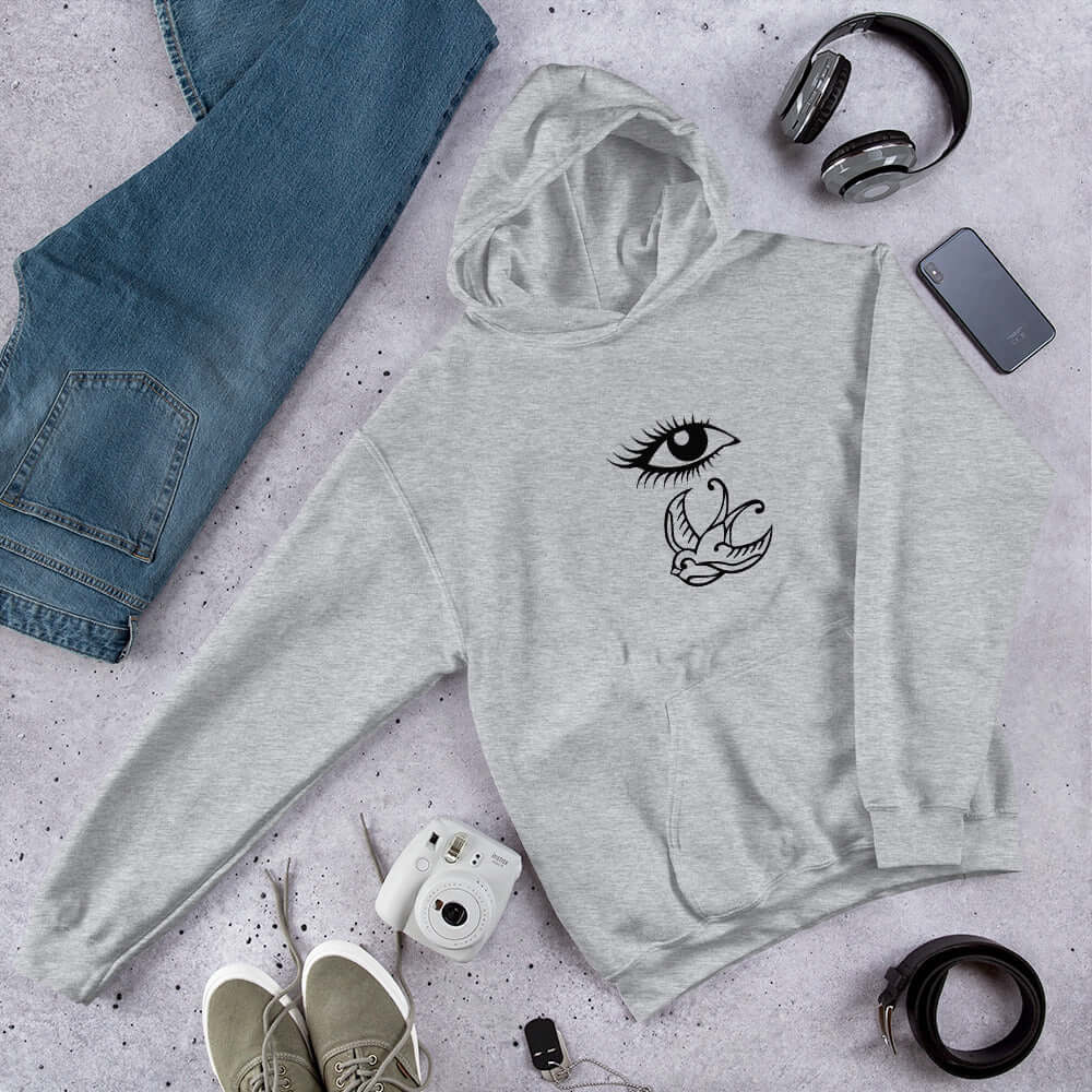 Sport grey hoodie sweatshirt with outline drawing of an eye and a swallow bird printed on the front.