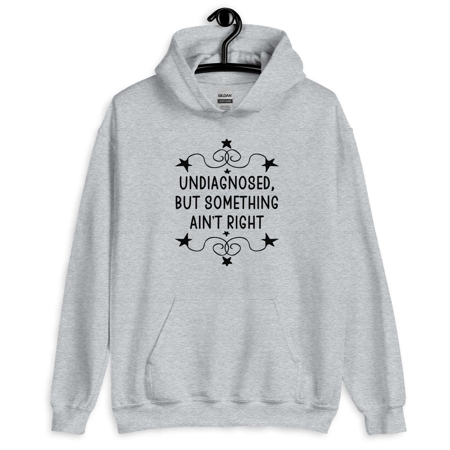 Sport grey hoodie sweatshirt with the phrase Undiagnosed, but something ain't right printed on the front. The text is black and has a star graphic embellishment around the words.