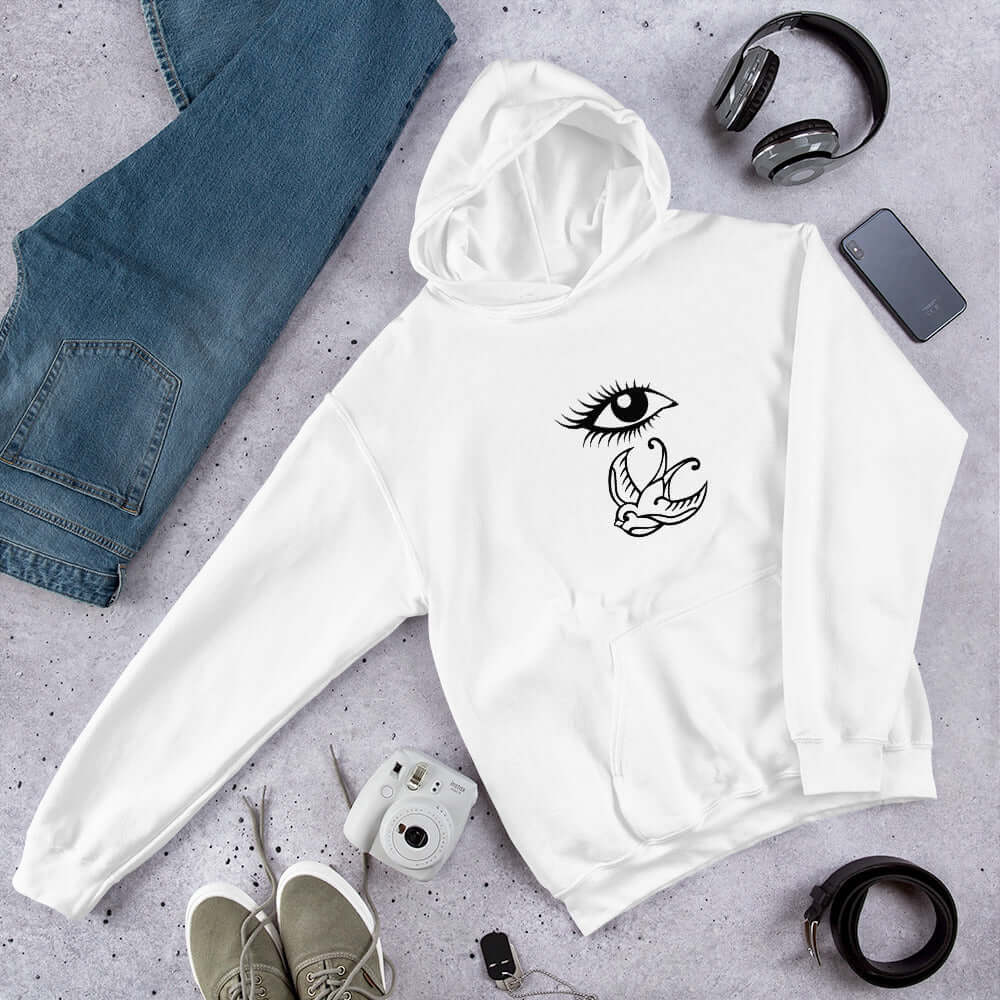 White hoodie sweatshirt with outline drawing of an eye and a swallow bird printed on the front.