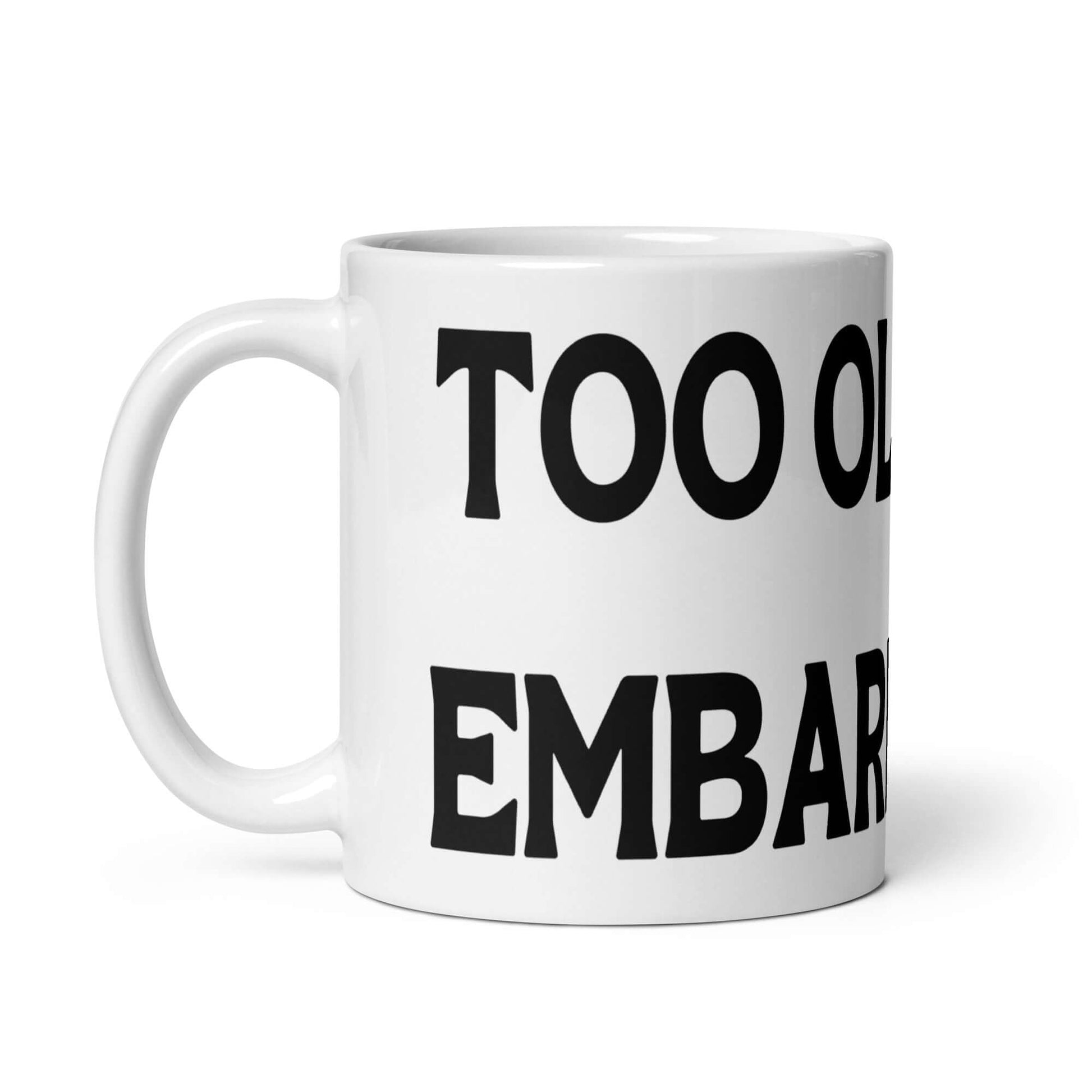 White ceramic mug with the words Too old to be embarrassed printed on it.