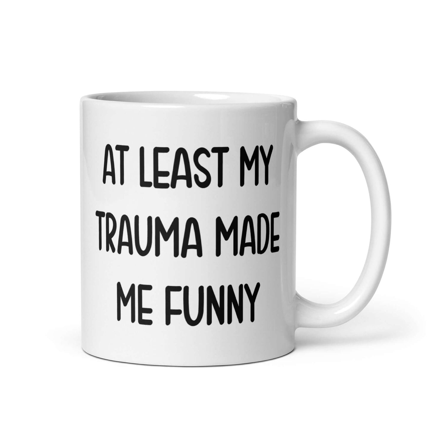 White ceramic mug with the words At least my trauma made me funny printed on both sides.