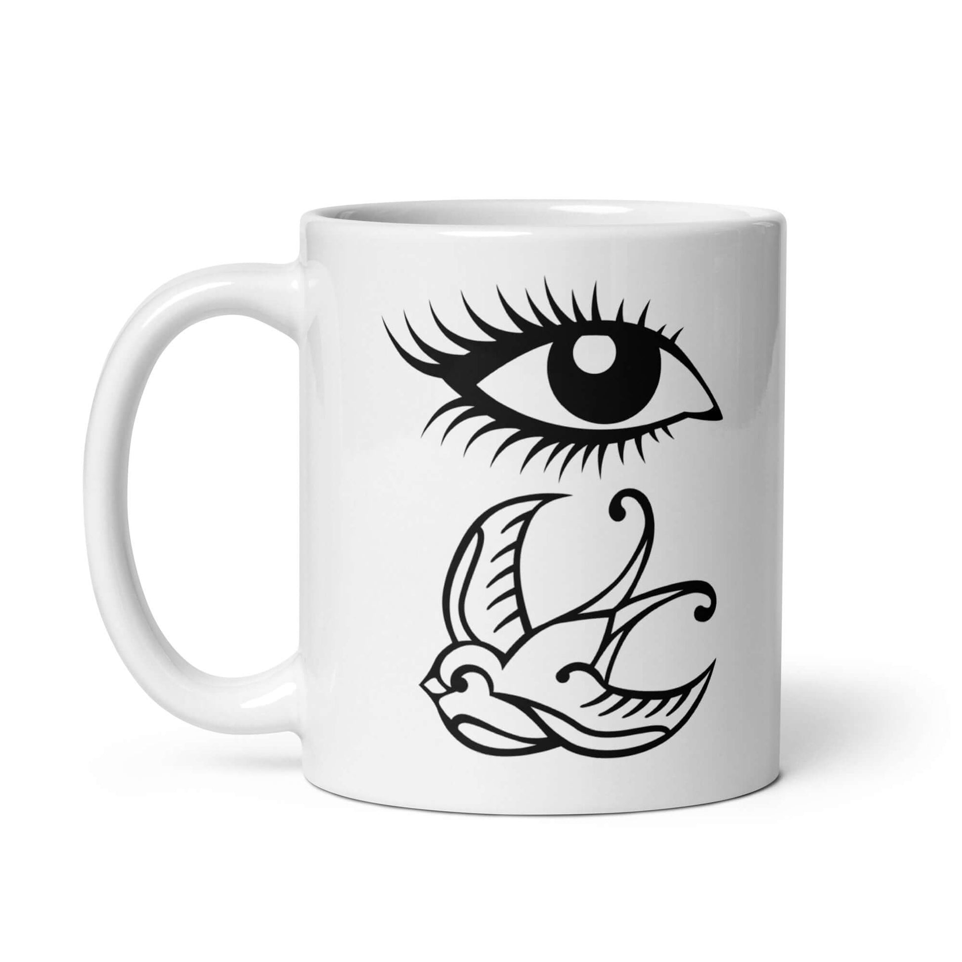 White ceramic mug with outline drawing of an eye and a swallow bird printed on both sides.