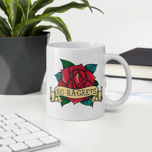 White ceramic coffee mug with a funny image of an old school rose flash tattoo & the words no ragrets. The word regrets is intentionally misspelled. The graphic is printed on both sides of the mug.