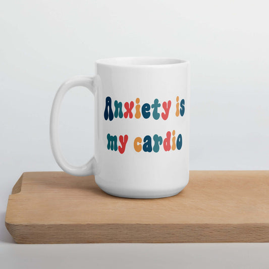 White ceramic mug with the phrase Anxiety is my cardio printed in multiple colors on both sides of the mug.