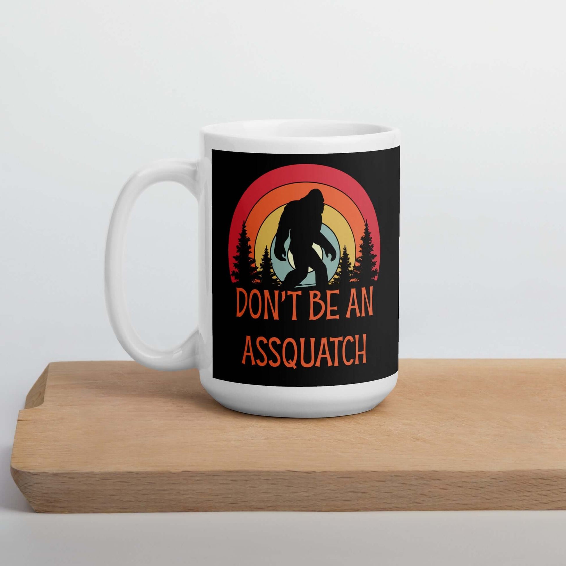 White ceramic coffee mug with sasquatch graphic and the words don't be an assquatch printed on both sides.