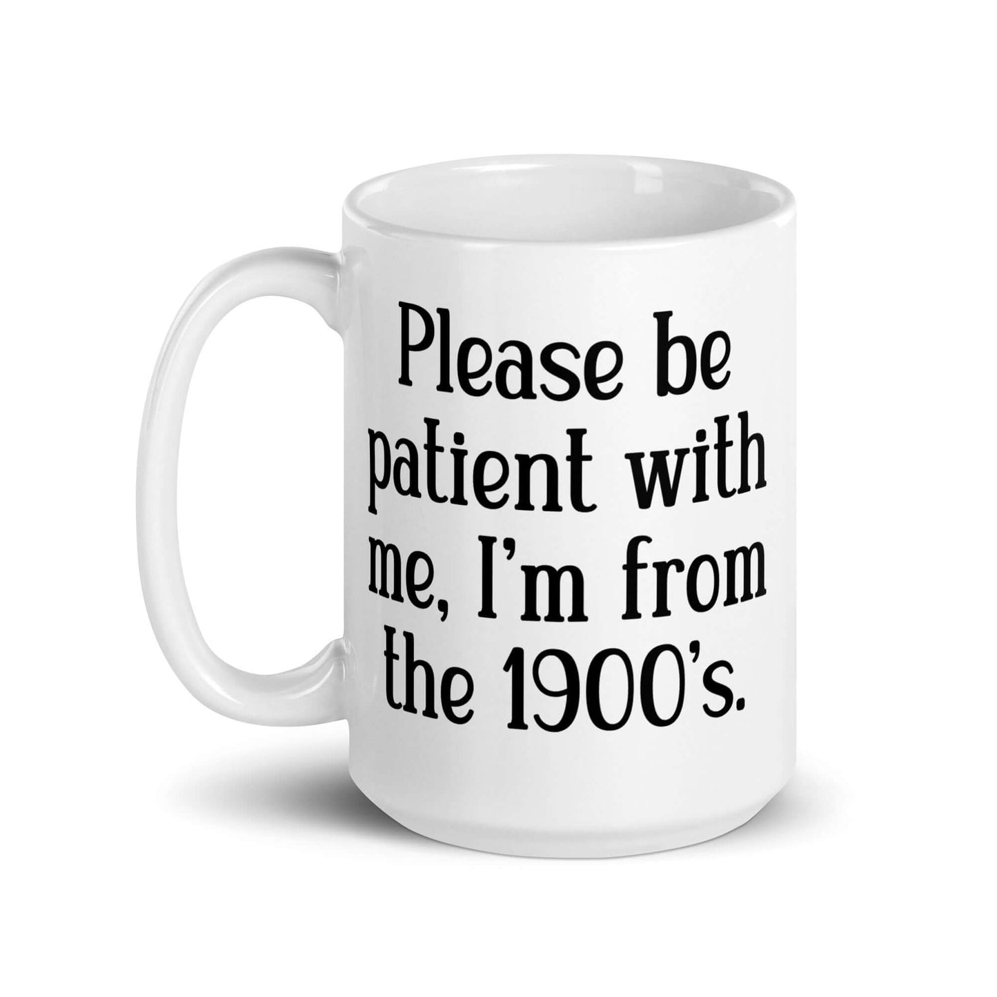 15 ounce white ceramic mug the phrase Please be patient with me, I'm from the 1900s printed on both sides.