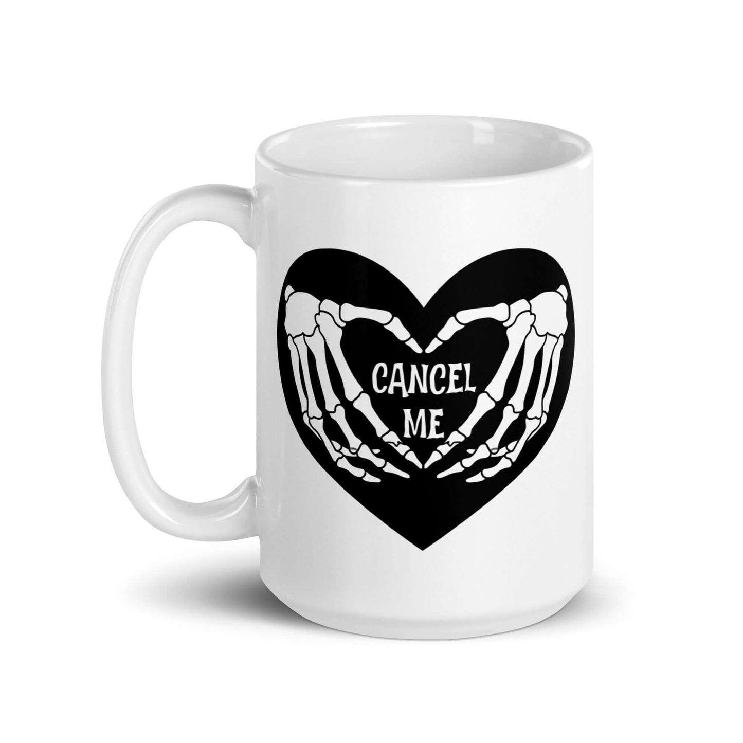 White ceramic mug with a black heart and skeleton hands making a heart shape. The words Cancel Me are inside of the heart. The graphics are printed on both sides of the mug.