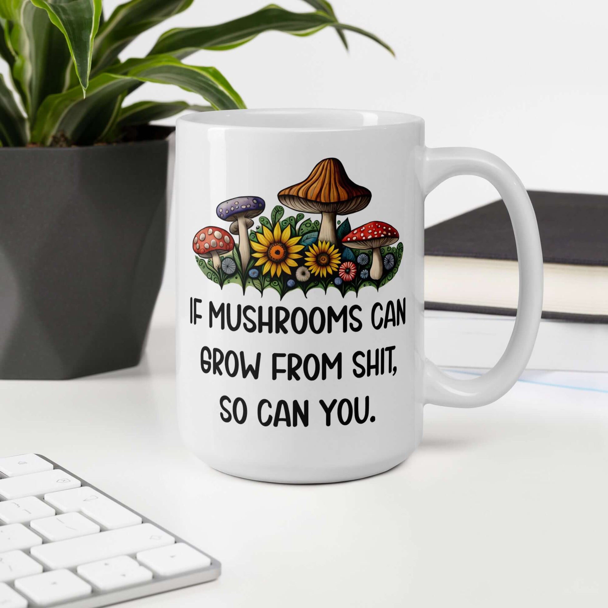 White ceramic mug with images of mushrooms and the phrase If mushrooms can grow from shit so can you printed on both sides of the mug.