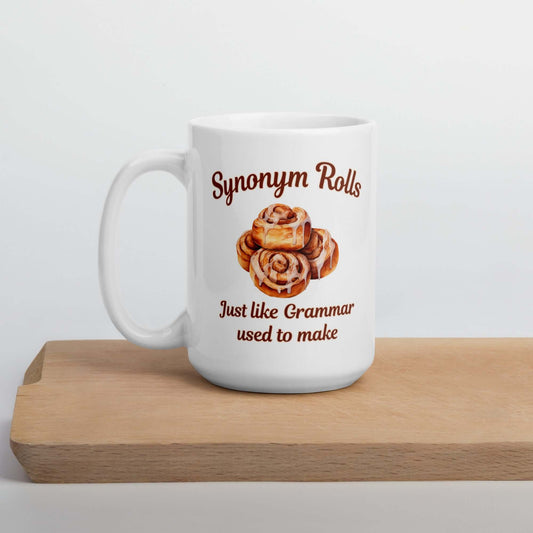 White ceramic coffee mug with an image of cinnamon rolls and the pun phrase Synonym rolls Just like Grammar used to make printed on both sides.