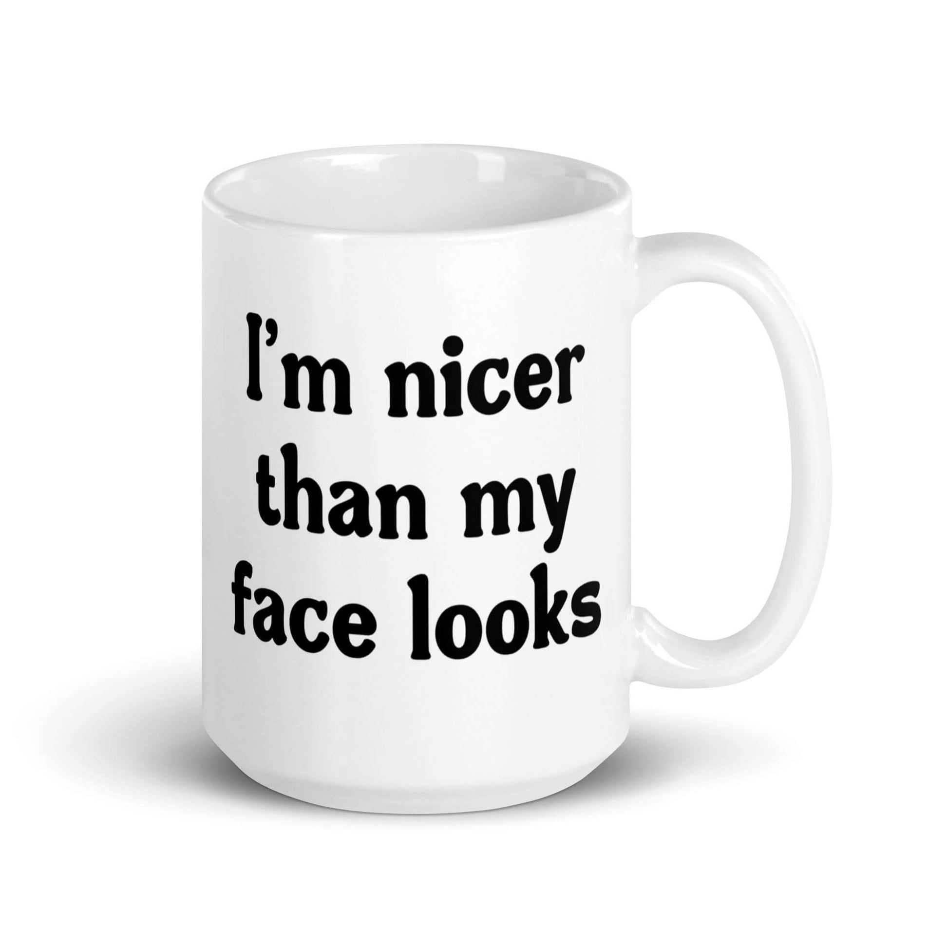 White ceramic coffee mug that says I'm nicer than my face looks printed on both sides of the mug.