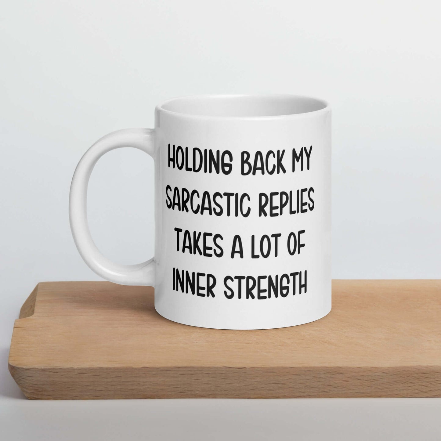 White ceramic mug with the phrase Holding back my sarcastic replies takes a lot of inner strength printed on both sides of the mug.