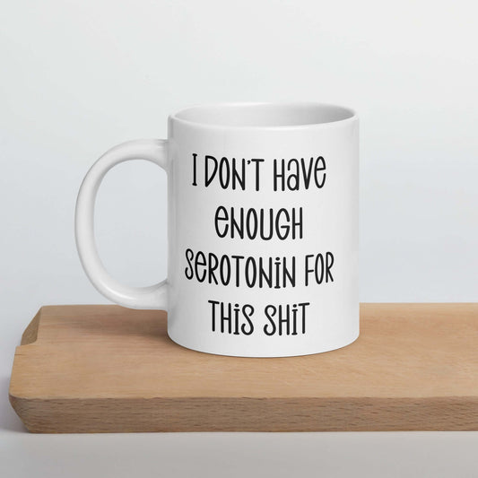 White ceramic coffee mug with the phrase I don't have enough serotonin for this shit printed on both sides.