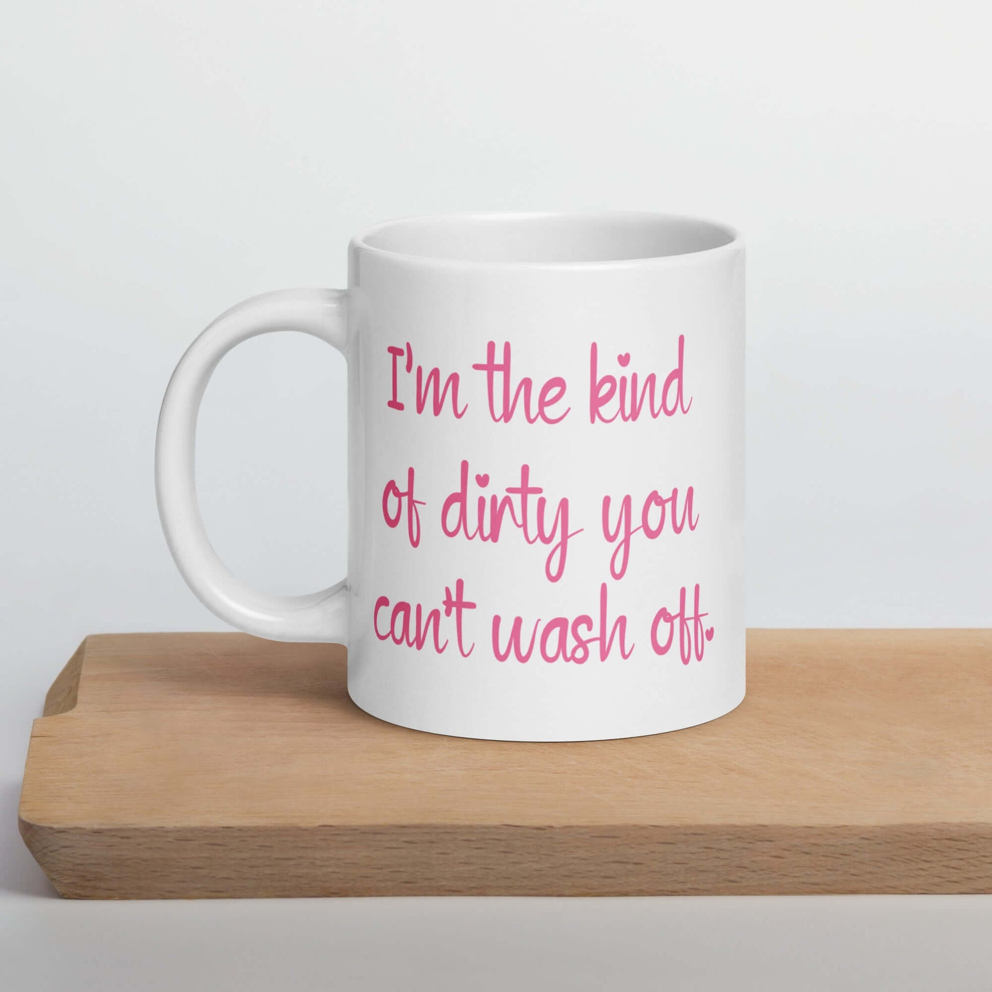 White coffee mug with the words I'm the kind of dirty you can't wash off printed in pink on both sides of the mug.