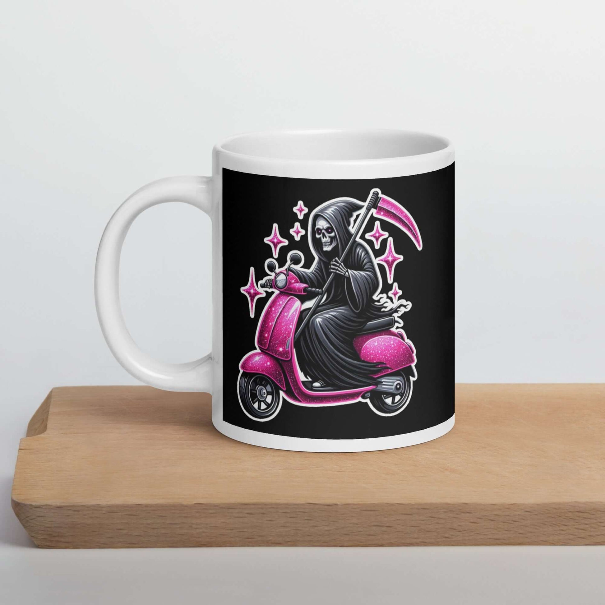 Coffee mug with graphic of a Grim reaper riding a pink scooter with pink embellishments 