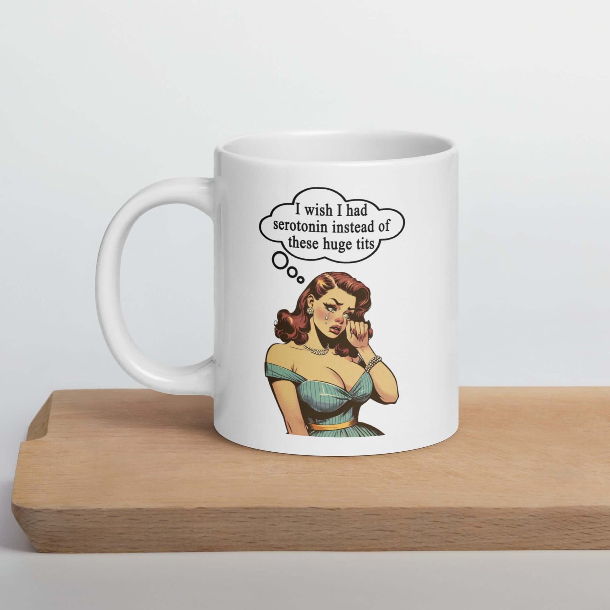 White ceramic coffee mug with an image of a busty pin-up lady with thought bubble that says I wish I had serotonin instead of these huge tits printed on both sides of the mug.