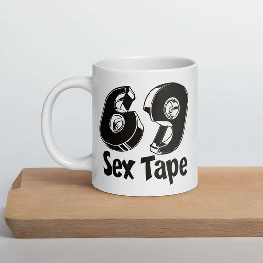 White ceramic mug with image of 2 tape dispensers forming the numbers 6 and 9. The words Sex Tape are printed below the tape. The graphics are printed on both sides of the mug.