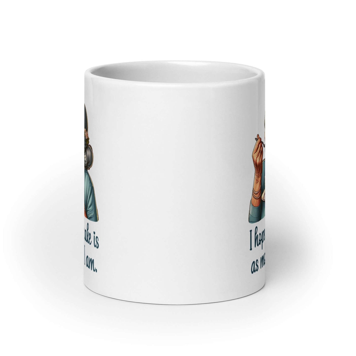 White ceramic coffee mug with an image of grey haired older woman enjoying a bite of a piece of cake with the words I hope your cake is as moist as I am printed on both sides.