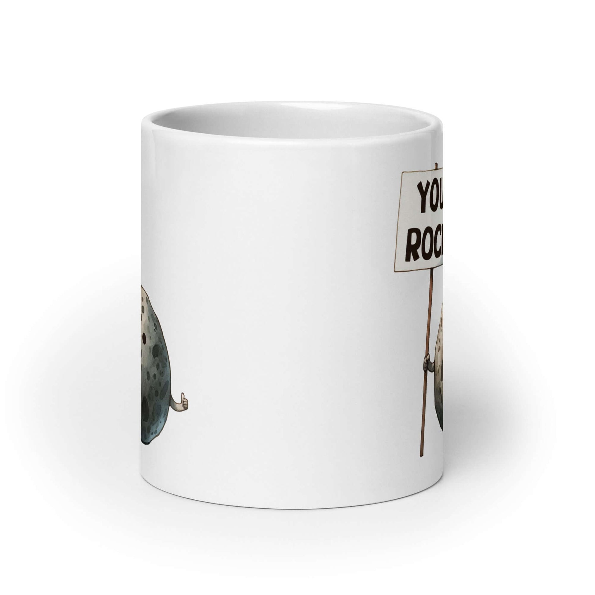 White ceramic mug that has an image of a grey rock that is holding a sign. The sign says You Rock. The image is printed on both sides of the mug.