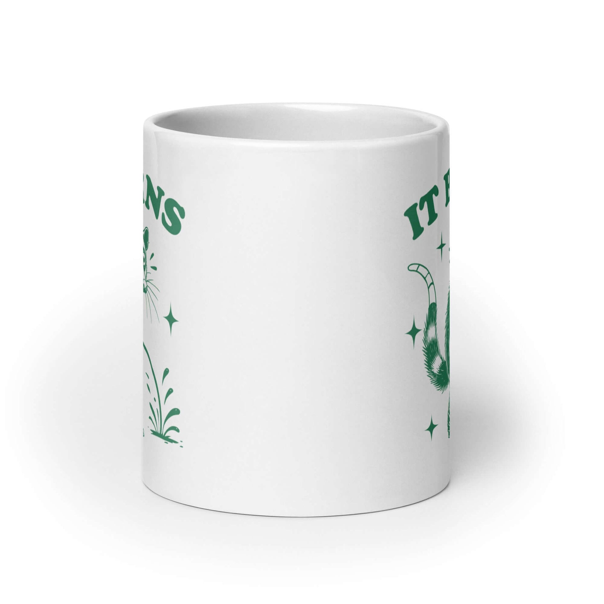 White ceramic mug with an image of an opossum peeing. The words It burns are printed above.