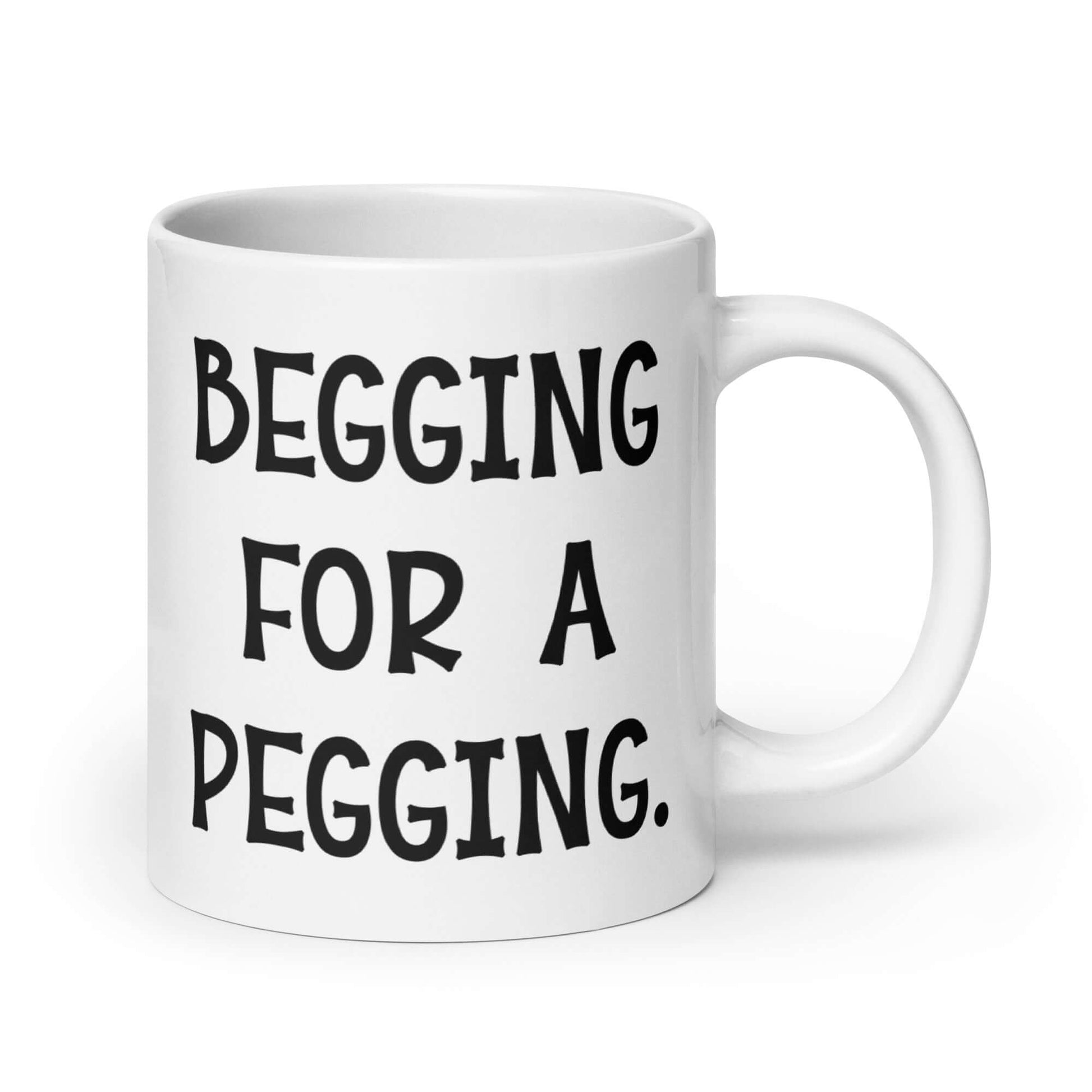 White ceramic coffee mug with the words Begging for a pegging printed on both sides.
