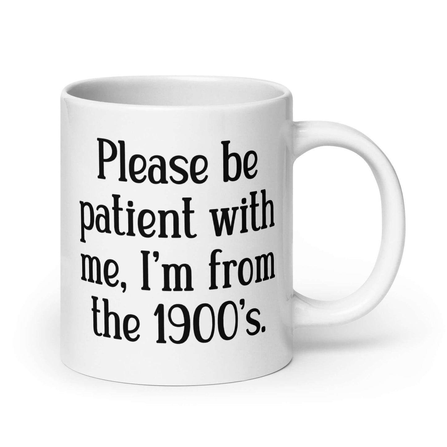 20 ounce white ceramic mug the phrase Please be patient with me, I'm from the 1900s printed on both sides.