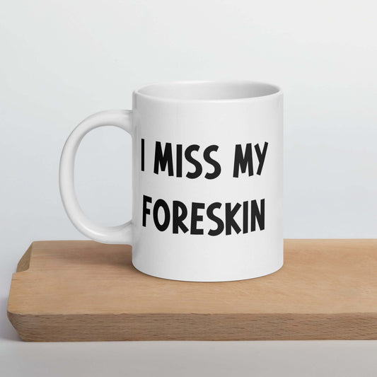 White ceramic mug with the words I miss my foreskin printed on both sides.