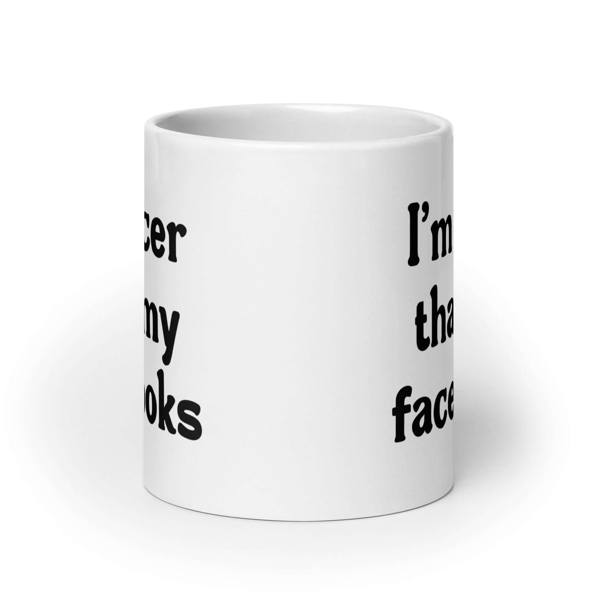 White ceramic coffee mug that says I'm nicer than my face looks printed on both sides of the mug.