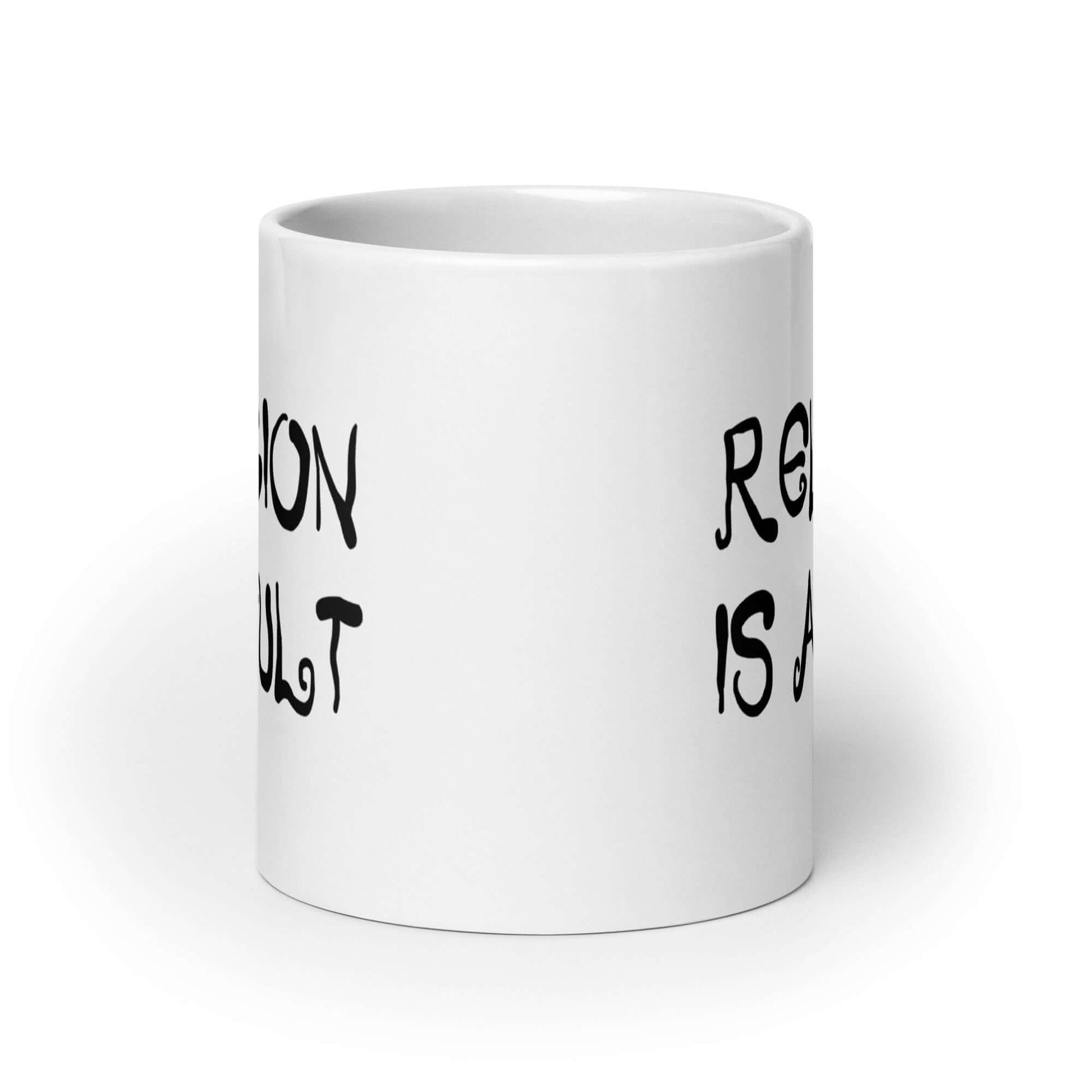 White ceramic coffee mug with the words Religion is a cult printed on both sides.