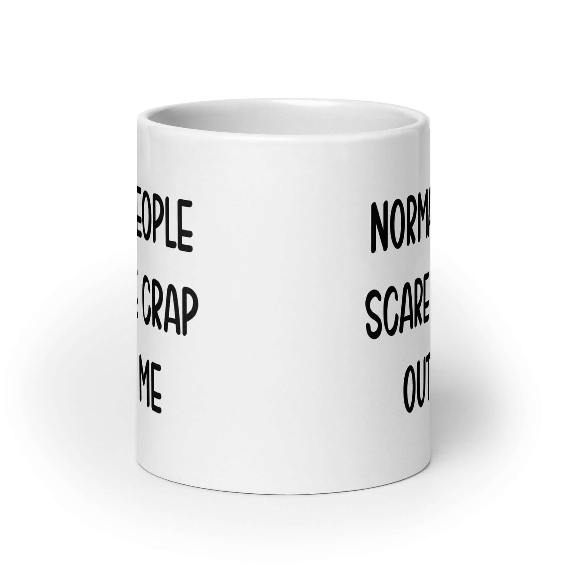 White ceramic coffee mug with the phrase Normal people scare the crap out of me printed on both sides.