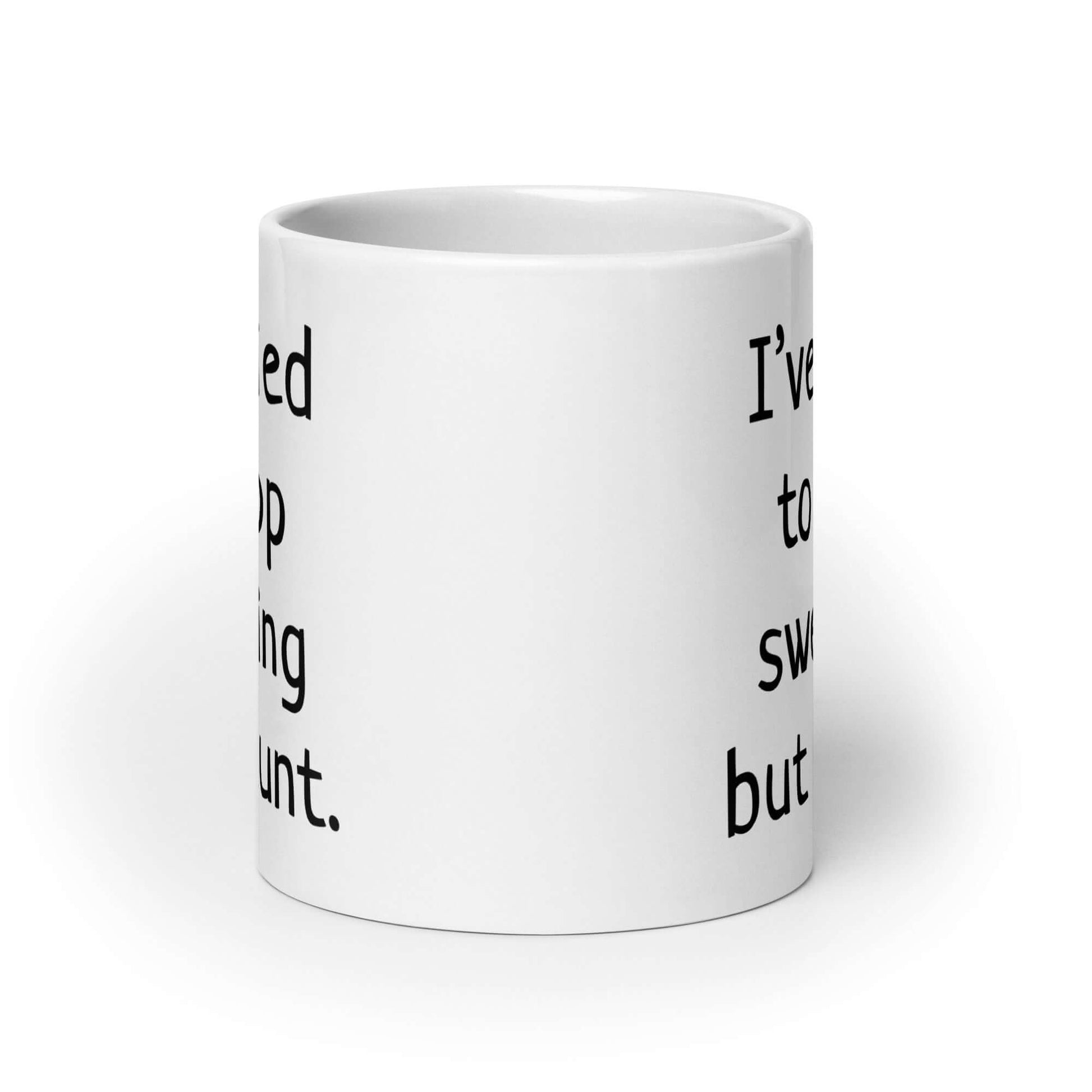 White ceramic coffee mug with the phrase I've tried to stop swearing but I cunt printed on both sides.