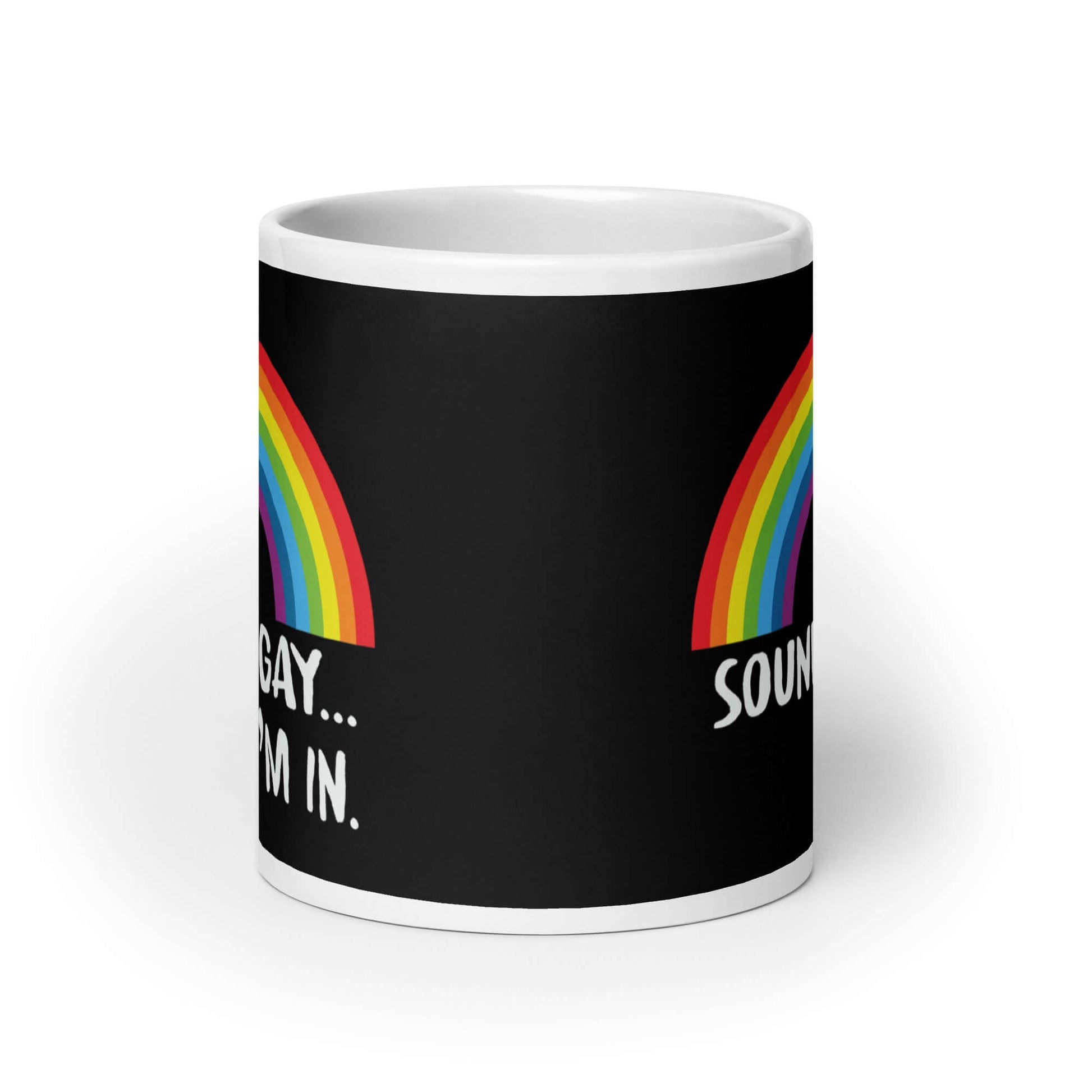 Black and white ceramic coffee mug that has an image of a rainbow and the phrase Sounds gay, I'm in printed on both sides.