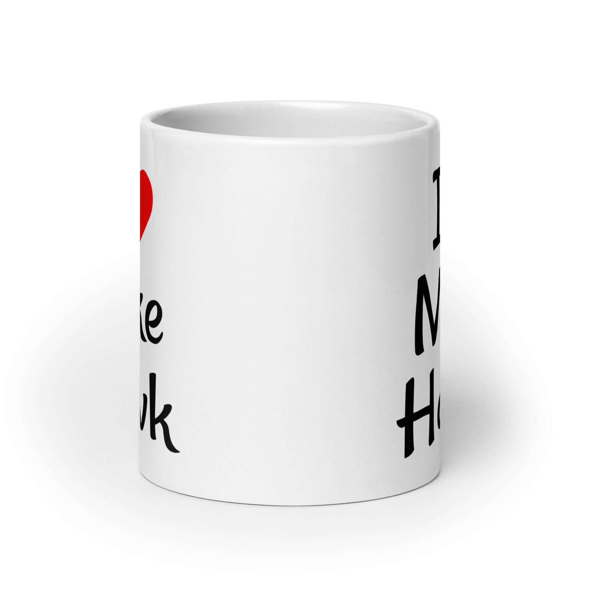 White ceramic coffee mug with the pun I heart Mike Hawk printed on both sides of the mug.