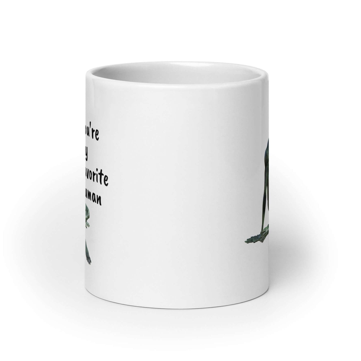 White ceramic coffee mug with funny image of an alien lounging and the words You're my favorite human printed on both sides of the mug.
