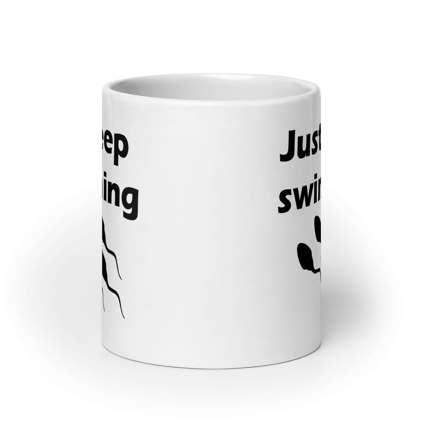 White ceramic coffee mug with the phrase Just keep swimming printed on both sides of the mug. There is an image of some swimming sperm underneath the words.
