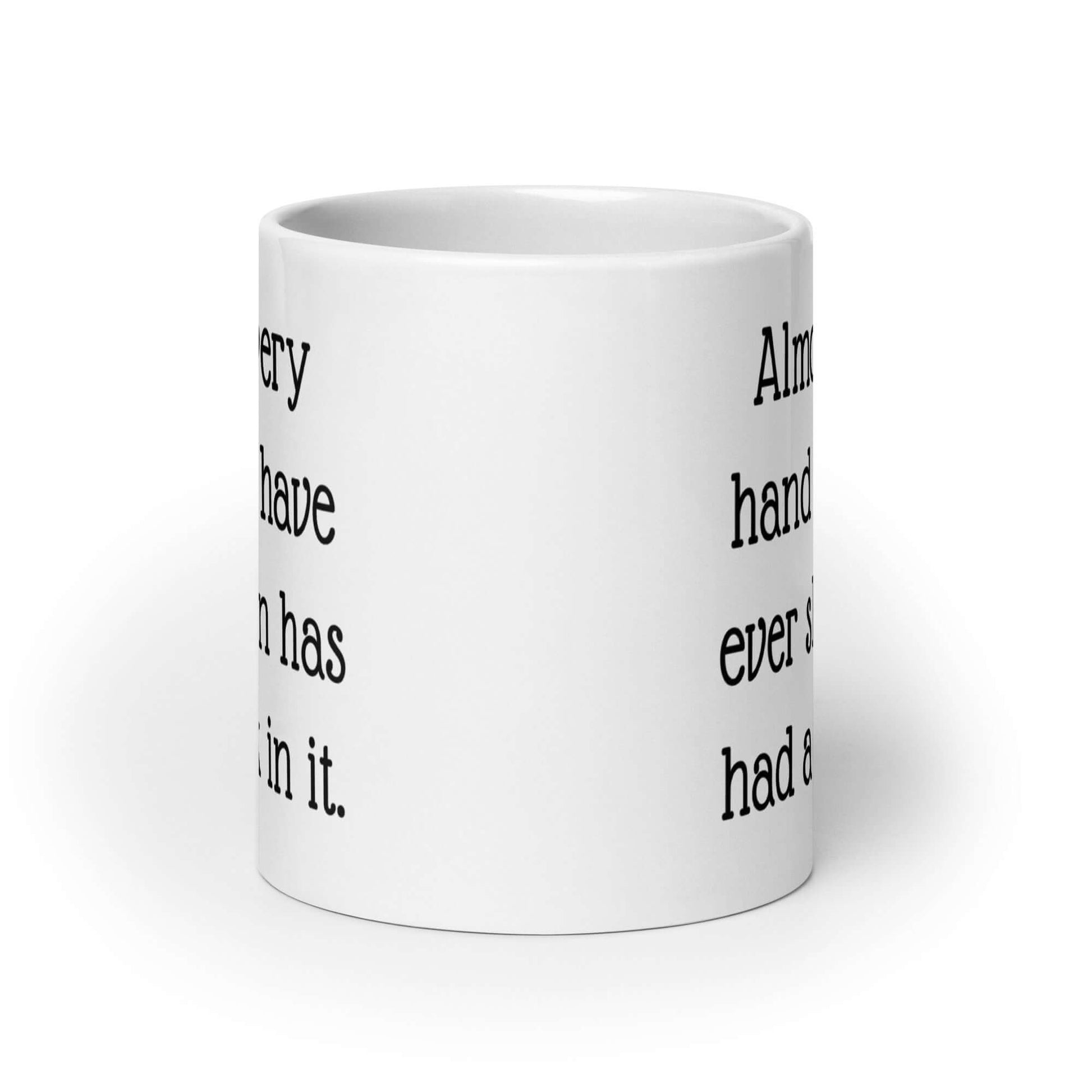 White ceramic coffee mug with the phrase Almost every hand you have ever shaken has had a dick in it printed on both sides.