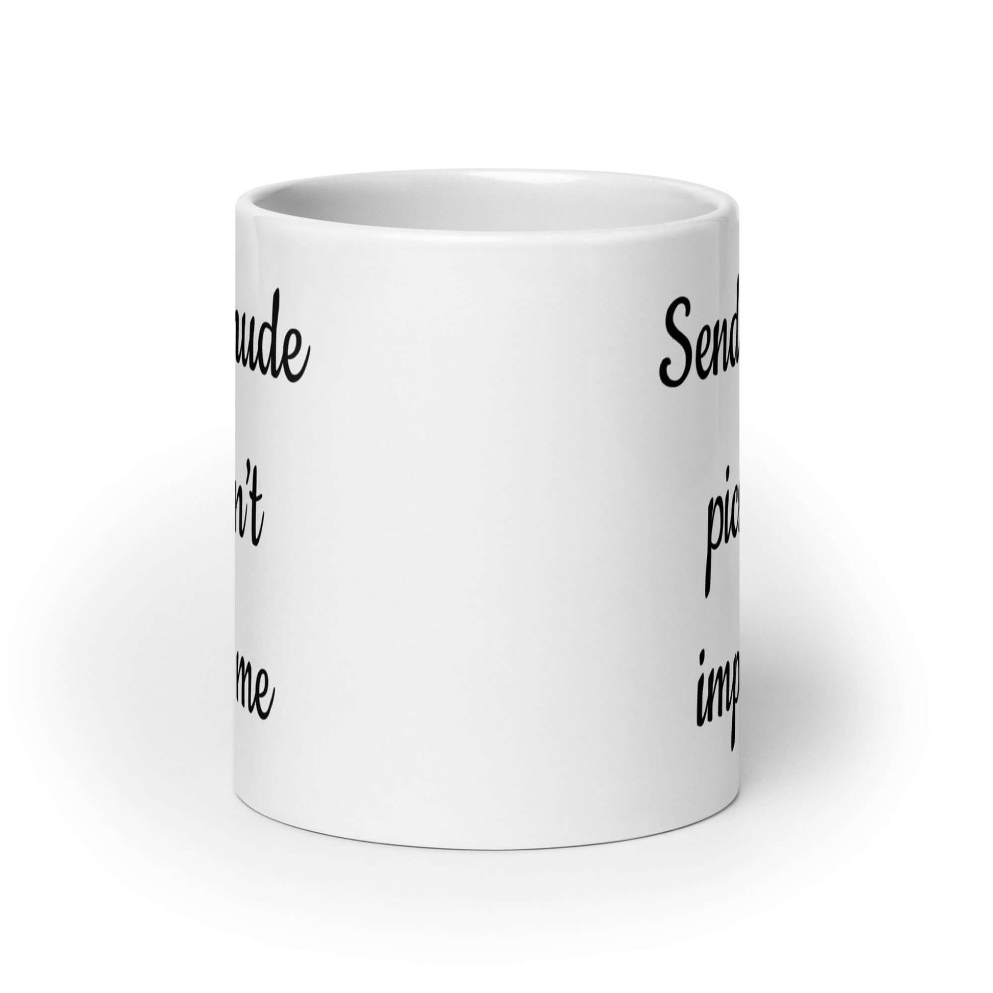 White ceramic coffee mug with the phrase Sending nude pic won't impress me printed on both sides of the mug.