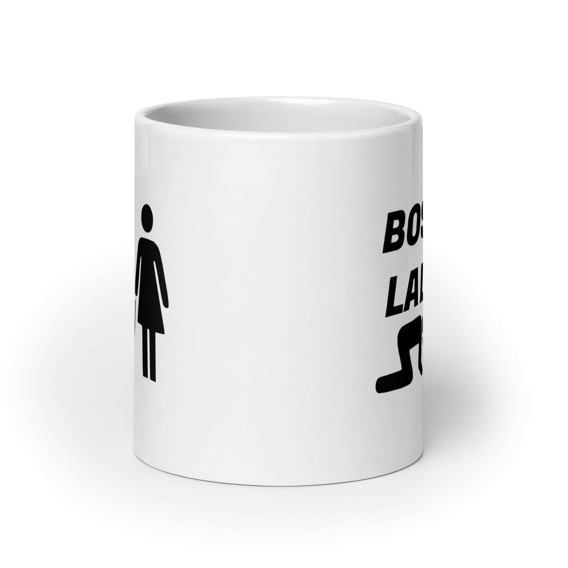 White ceramic mug with graphic of collared and leashed man on his hands and knees being led by a woman and the words Boss lady printed on both sides.
