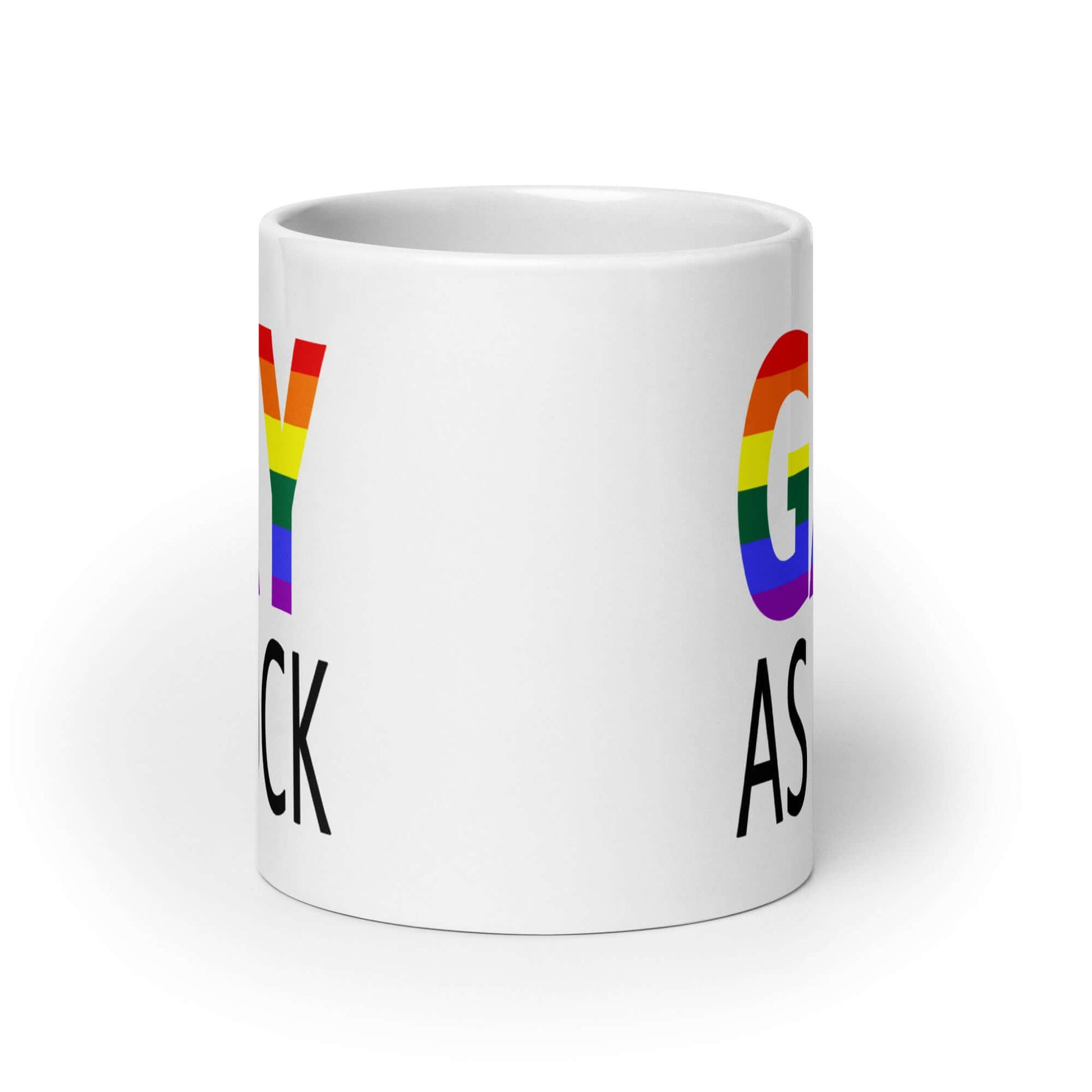 White ceramic mug with the words Gay as fuck printed on both sides. The word Gay is in rainbow stripe font.