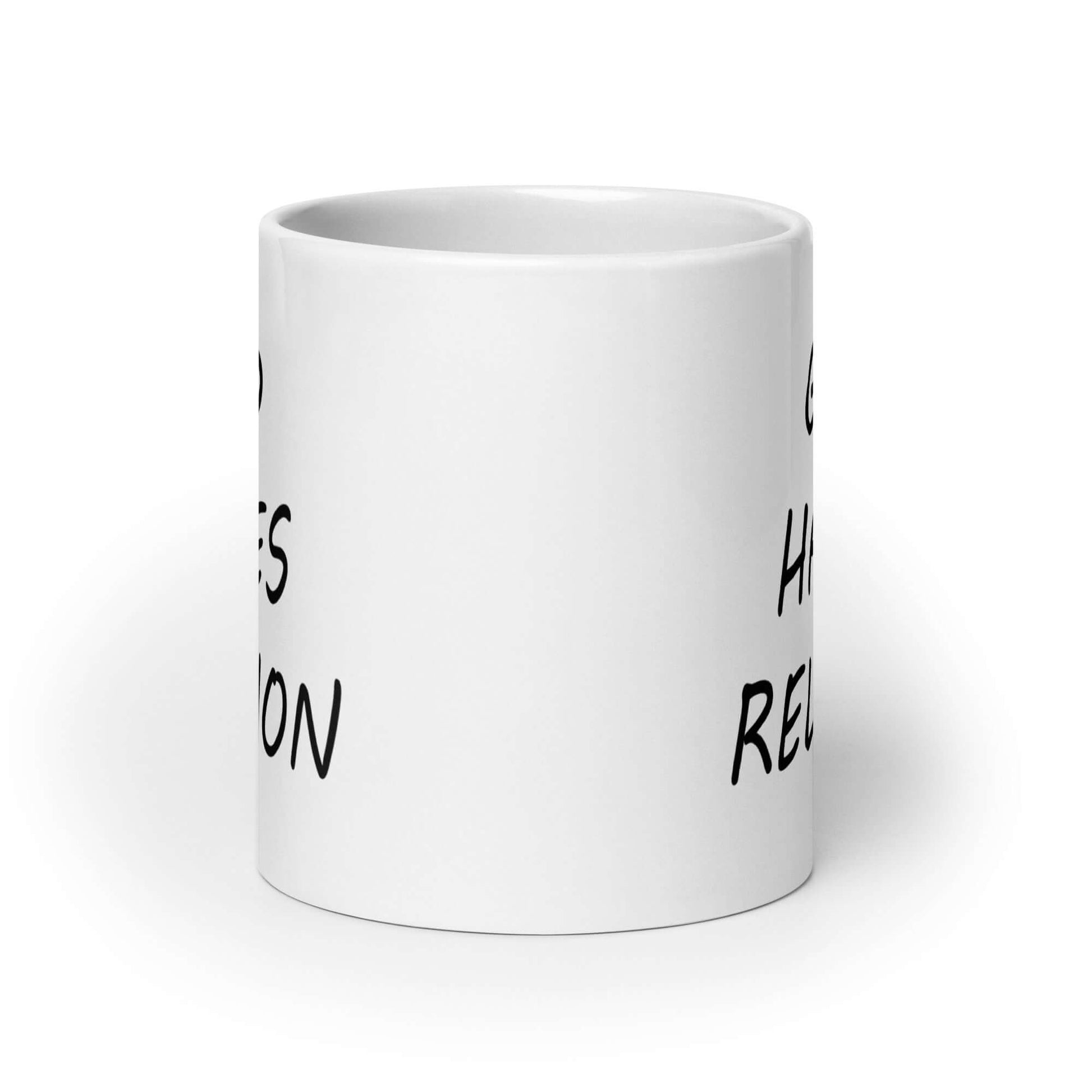 White ceramic mug with with the words God hates religion printed on both sides of the mug.