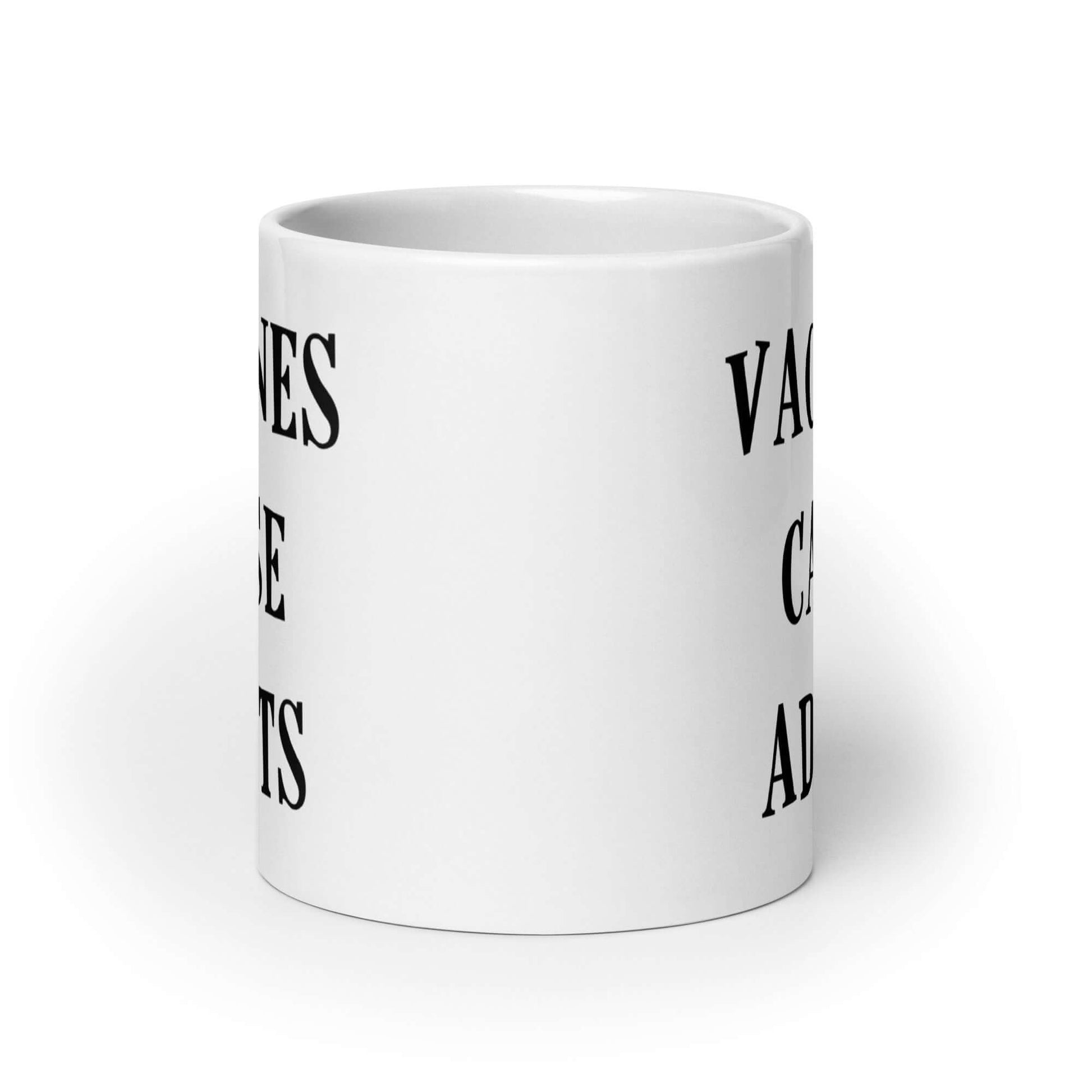 White ceramic mug with the words Vaccines cause adults printed on both sides.
