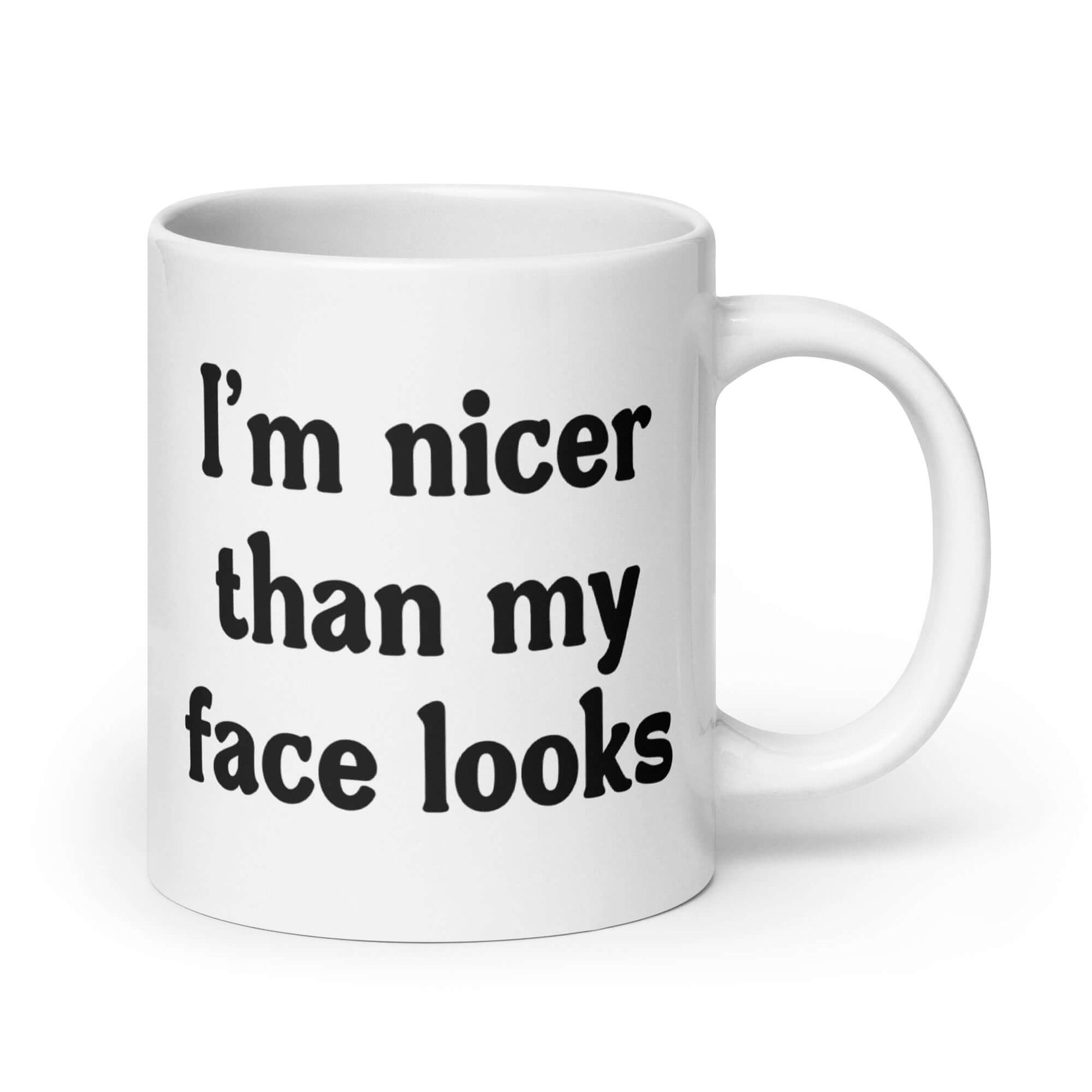 White ceramic coffee mug that says I'm nicer than my face looks printed on both sides of the mug.