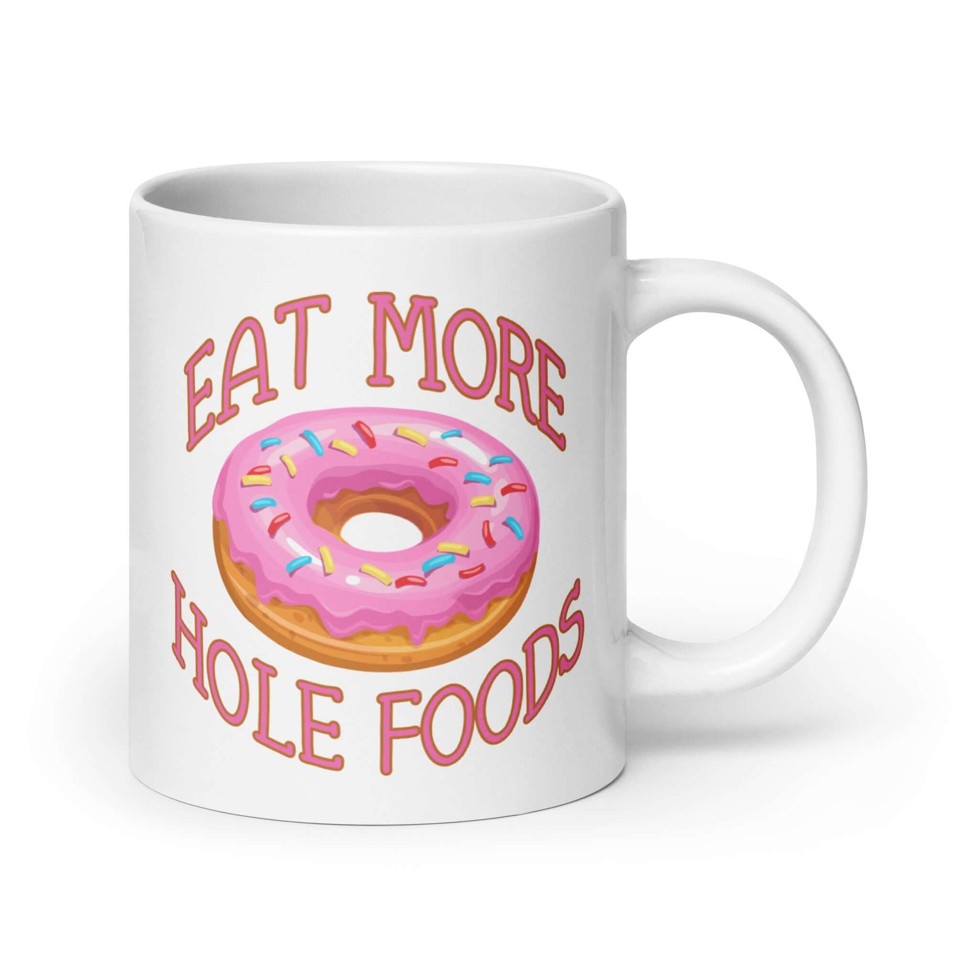 White coffee mug with an image of a donut with pink icing and sprinkles and the words Eat more hole foods printed on both sides.