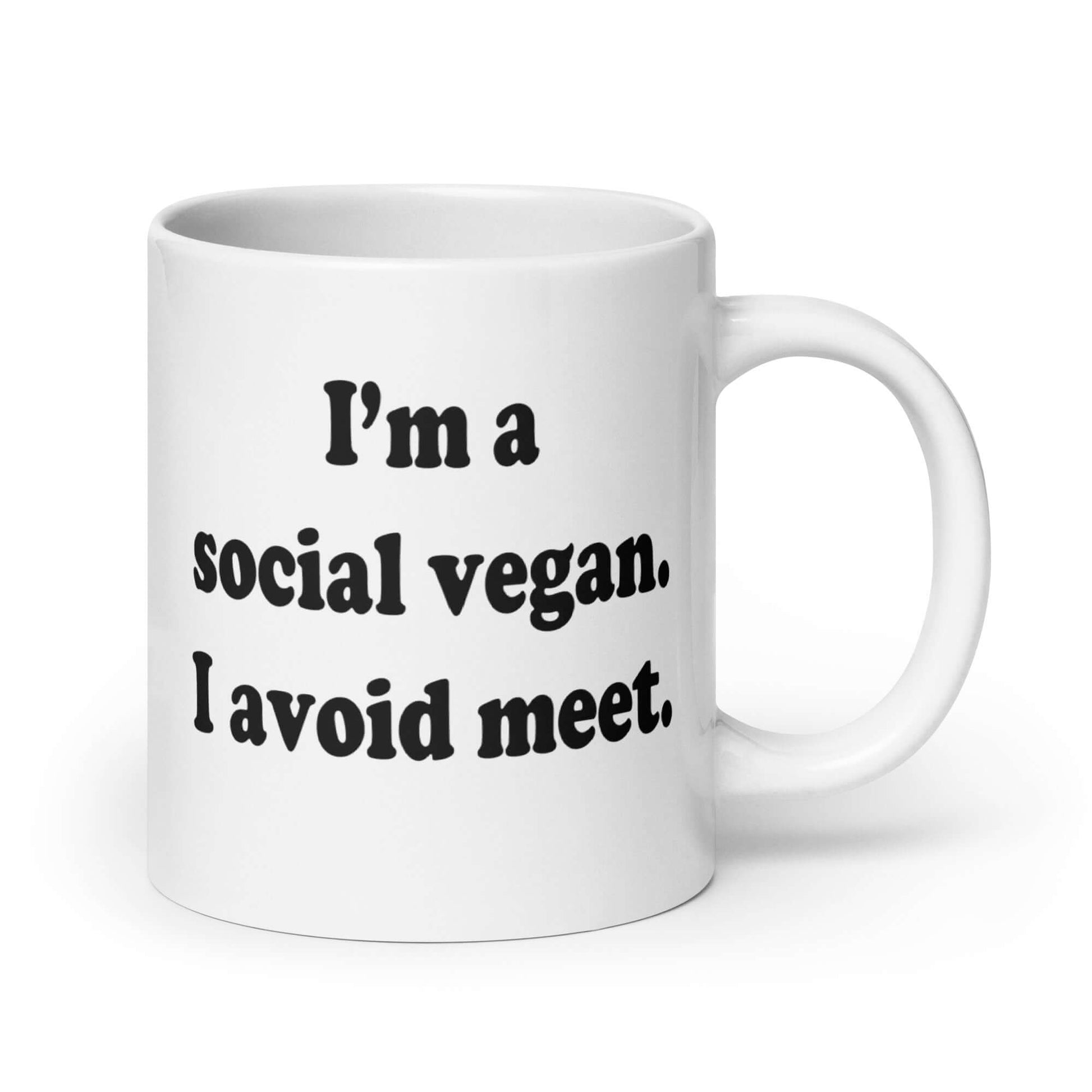 White ceramic coffee mug with the pun phrase I'm a social vegan, I avoid meet printed on both sides.